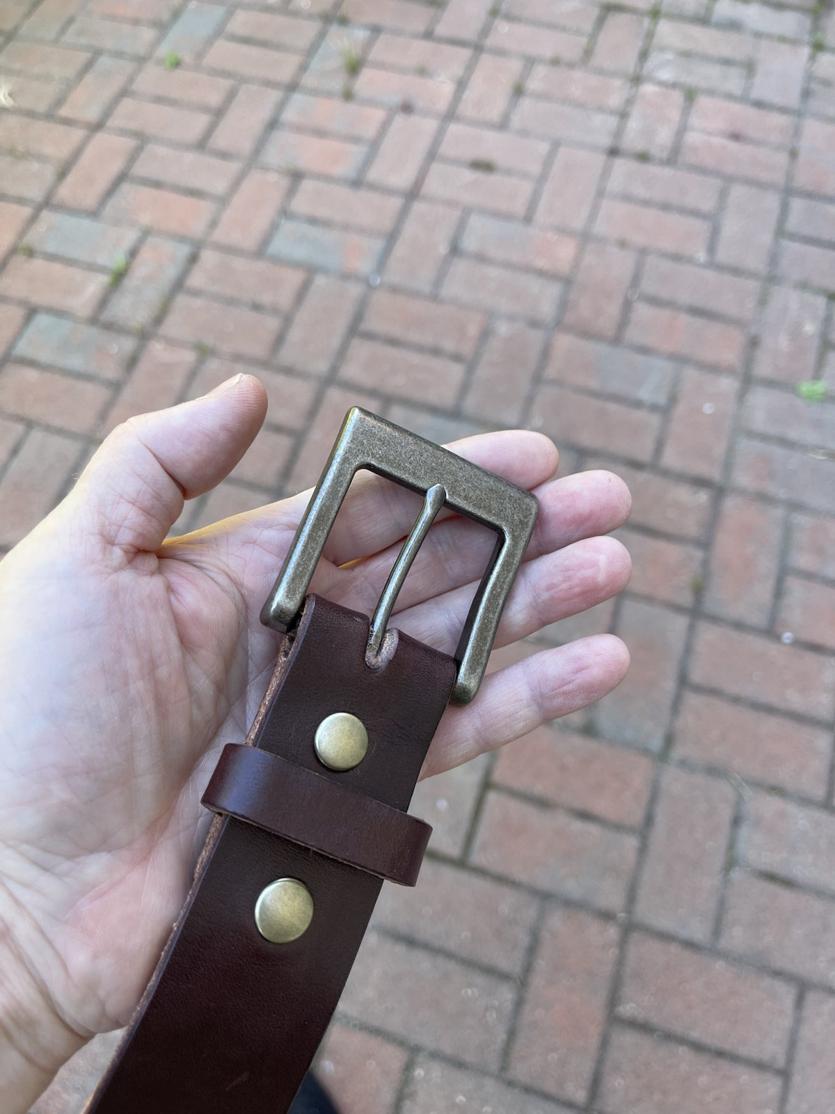 Havana Brown leather belt held in hand